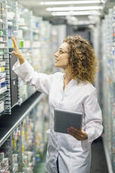 Apotheker mit Tablet-PC bei der Prüfung von Medikamenten in der Apotheke - JSMF02908