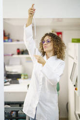 Pharmacist experimenting with pipette and test tube at laboratory of pharmacy - JSMF02917