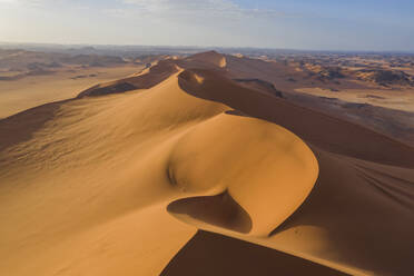 Sand dunes at sunset in the Wahiba Sands desert with clouds in the
