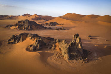 Luftaufnahme von Felsformationen zwischen Sanddünen bei Sonnenuntergang in der Wüste Sahara, Djanet, Algerien, Afrika. - AAEF22952