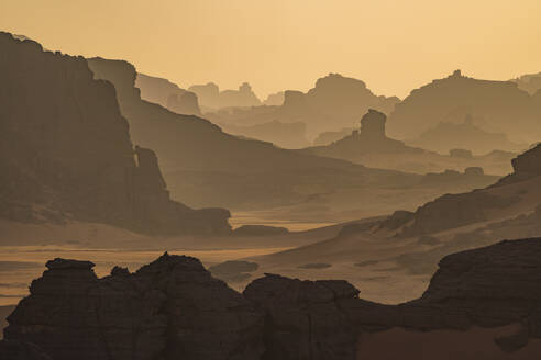 Luftaufnahme von Felsformationen zwischen Sanddünen bei Sonnenuntergang in der Wüste Sahara, Djanet, Algerien, Afrika. - AAEF22954