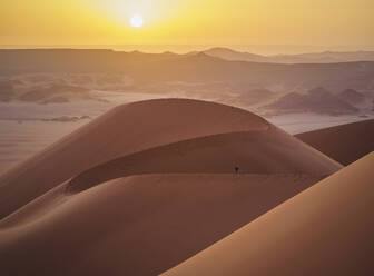 Luftaufnahme eines Spaziergängers auf den Sanddünen bei Sonnenuntergang in der Wüste Sahara, Djanet, Algerien, Afrika. - AAEF22961