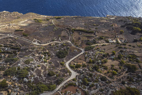 Aerial view of a road along the cliff facing the Ocean in Dingli, Malta. - AAEF23129