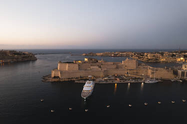 Luftaufnahme einer Yacht, die bei Sonnenuntergang am Fort Saint Angelo, La Valletta, Malta, vor Anker liegt. - AAEF23182