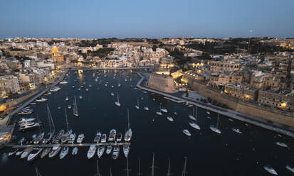 Aerial view of many sailboat docked at the harbour in La Valletta downtown at sunset in Malta. - AAEF23185
