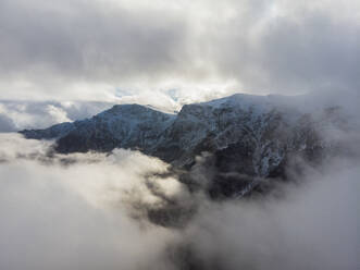 Aerial drone View of Snowy Mountains Through the Clouds, Valevtsi, Gabrovo, Bulgaria. - AAEF23199