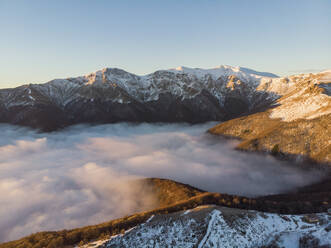 Aerial Drone View of misty Balkan Mountains in the Sunrise, Peeshti mountain peak in winter, Valevtsi, Gabrovo, Bulgaria. - AAEF23213