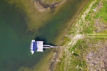 Aerial view of a boat docked along Tsonevo Reservoir, Asparukhovo, Varna, Bulgaria. - AAEF23217