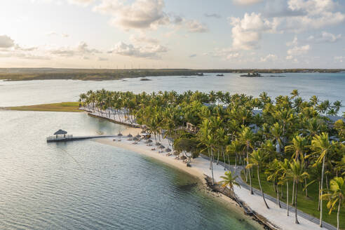 Luftaufnahme eines Luxusresorts mit Sonnenschirmen entlang der Küste bei Sonnenuntergang, Poste de Flacq, Bezirk Flacq, Mauritius. - AAEF23233