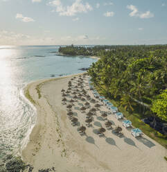 Panorama-Luftaufnahme von Sonnenschirmen am Strand entlang der Küste in Poste de Flacq, Bezirk Flacq, Mauritius. - AAEF23239