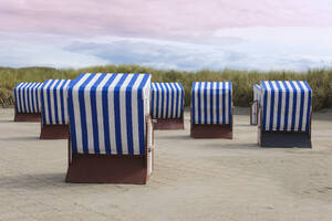 Deutschland, Niedersachsen, Strandkörbe mit Kapuze auf gepflasterter Promenade auf der Insel Norderney - WIF04691