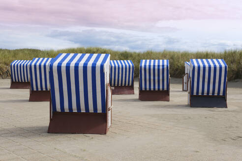 Germany, Lower Saxony, Hooded beach chairs on paved promenade on Norderney island - WIF04691