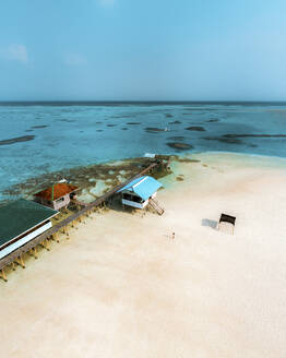 Aerial view of a woman walking on sandbar near the pier at Balabac, Candaraman Island, Palawan, Philippines. - AAEF23325