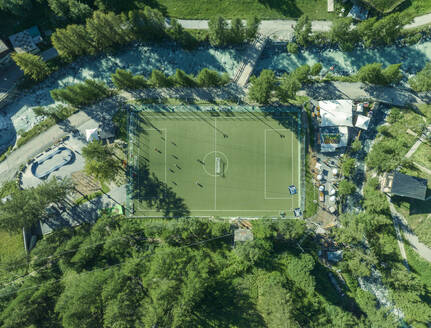 Aerial view of people playing in a football field in Zermatt on the Swiss Alps, Valais, Switzerland. - AAEF23357