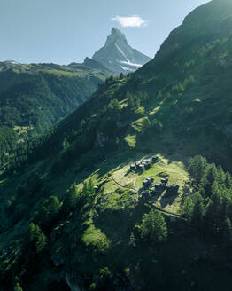 Aerial view of the Matterhorn, an iconic mountain peak with mountain wooden houses on the Swiss Alps in summertime, Valais, Switzerland. - AAEF23362