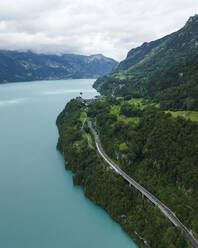 Aerial view of a road following the Brienzersee Lake coastline, Bonigen, Bern, Switzerland. - AAEF23375