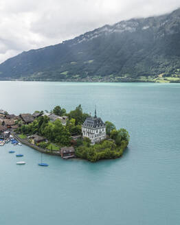 Aerial view of Iseltwald, a small town along the Brienzersee Lake coastline in summertime with rain and low clouds, Bern, Switzerland. - AAEF23384