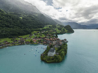 Aerial view of Iseltwald, a small town along the Brienzersee Lake coastline in summertime with rain and low clouds, Bern, Switzerland. - AAEF23385