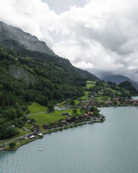 Aerial view of Iseltwald, a small town along the Brienzersee Lake coastline in summertime with rain and low clouds, Bern, Switzerland. - AAEF23397