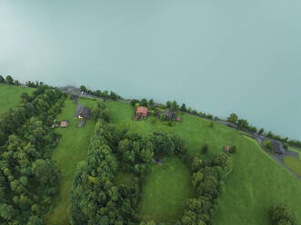 Aerial view of a road following the Brienzersee Lake coastline, Bonigen, Bern, Switzerland. - AAEF23406