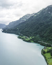 Aerial view of a road following the Brienzersee Lake coastline, Bonigen, Bern, Switzerland. - AAEF23410