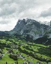 Aerial view of Grindelwald, a small town in the valley with the Wetterhorn mountain in background on the Swiss Alps, Canton of Bern, Switzerland. - AAEF23416