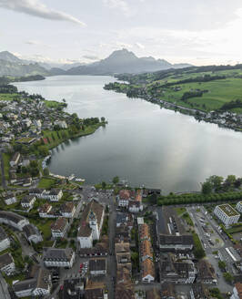 Aerial view of Kussnacht am Rigi town along Lake Lucerne with Mount Pilatus mountain peak in background, Alpnach, Switzerland. - AAEF23463