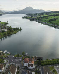 Aerial view of Kussnacht am Rigi town along Lake Lucerne with Mount Pilatus mountain peak in background, Alpnach, Switzerland. - AAEF23464