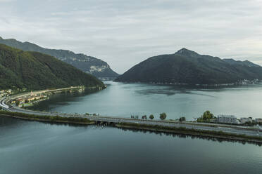 Aerial view of a road crossing the Lugano lake at sunset, Melide, Ticino, Switzerland. - AAEF23472