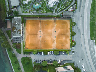 Aerial view of a tennis court in Melide, a small town along the Lugano Lake at sunset in Ticino, Switzerland. - AAEF23478