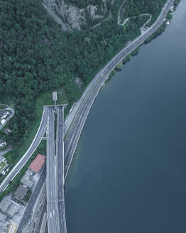 Aerial view of a road and a railway following the Lugano Lake coastline in Melide, Ticino, Switzerland. - AAEF23486