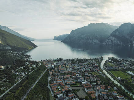 Aerial view of Torbole, a small town along the Garda Lake with Sarca river crossing the village at sunset, Trentino, Italy. - AAEF23497