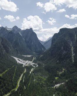 Aerial view of a road across the valley at Tre Cime Natural Park on the Dolomites mountain range, Toblach, Trentino, South Tyrol, Italy. - AAEF23631