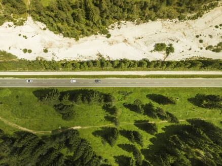 Aerial view of vehicles driving on the road crossing the valley across Tre Cime Natural park (Drei Zinnen) on the Dolomites area, Trentino, South Tyrol, Italy. - AAEF23659