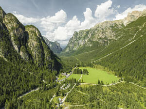 Aerial view of a road crossing the valley across Tre Cime Natural park (Drei Zinnen) on the Dolomites area, Trentino, South Tyrol, Italy. - AAEF23674