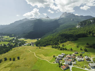 Aerial view of houses in a valley with mountain in background near Cortina d'Ampezzo, Belluno province, Dolomites area, Veneto, Italy. - AAEF23689