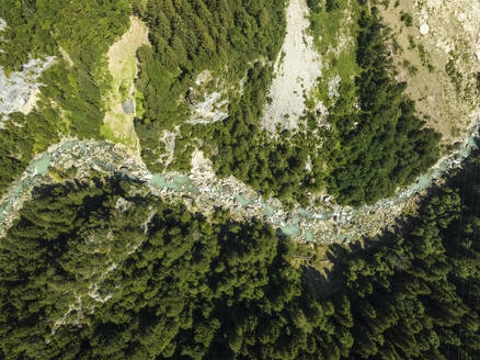 Aerial view of a river across the forest on the mountain crest in Valle di Cadore Lake, a mountain lake on the Dolomites, Veneto, Belluno, Italy. - AAEF23696