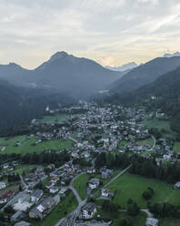 Luftaufnahme von Valle di Cadore, einer kleinen Stadt in einem Tal zwischen den Dolomiten bei Sonnenuntergang, Venetien, Belluno, Italien. - AAEF23731