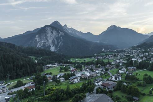 Luftaufnahme von Valle di Cadore, einer kleinen Stadt in einem Tal zwischen den Dolomiten bei Sonnenuntergang, Venetien, Belluno, Italien. - AAEF23732