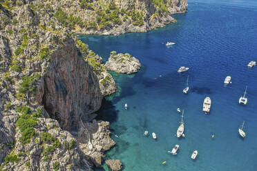 Luftaufnahme von Booten, Jachten und Segelbooten im klaren blauen Wasser neben einem felsigen Berg am Strand von Sa Calobra auf den Balearen, Spanien. - AAEF23816