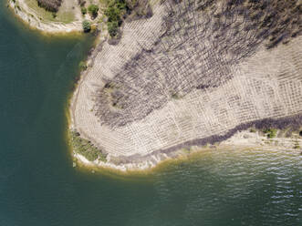 Aerial Top Down View of logged forest near to the lake, Bulgaria. - AAEF23910