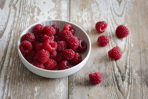 Bowl of fresh raspberries on wooden surface - EVGF04405