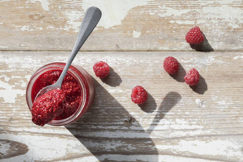 Jar of raspberry jam on wooden surface - EVGF04406