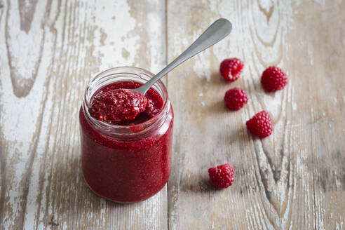 Jar of raspberry jam on wooden surface - EVGF04407