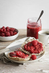 Studioaufnahme von Dinkelbrötchen mit Himbeermarmelade - EVGF04411