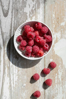 Bowl of fresh raspberries on wooden surface - EVGF04412