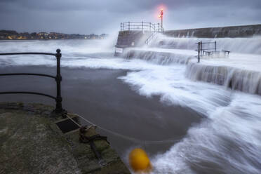 UK, Scotland, North Berwick, Long exposure of waves splashing against harbor walls during Storm Babet - SMAF02638