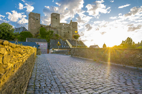 Germany, Hesse, Runkel, Cobblestone bridge in front of Runkel Castle at sunset - MHF00734