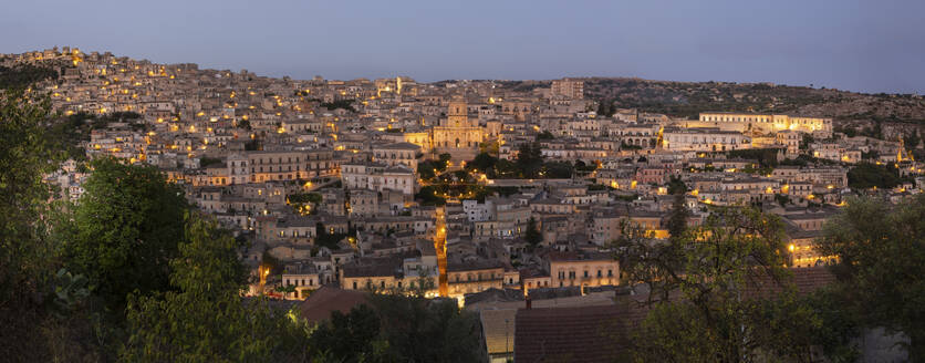 Italy, Sicily, Modica, Panoramic view of old town district at dusk - FCF02164