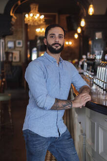 Owner Standing near bar counter at pub - ASGF04724